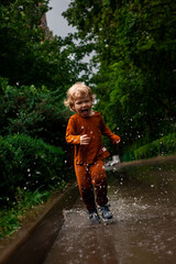 a little boy runs and jumps in the puddles during the summer rain.Childhood.