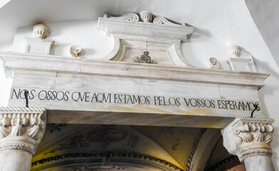 Evora, Portugal - August 03 2019: Bones Chapel in Evora. Entrance - written in Portuguese is the sentence:  "we bones that are here wait for yours"