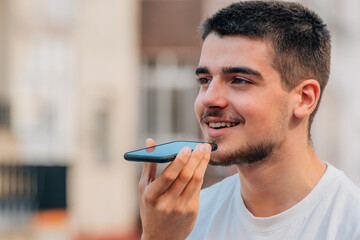 young man with mobile phone sending voice message