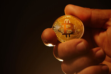 golden bitcoin close-up held in hand on a warm background