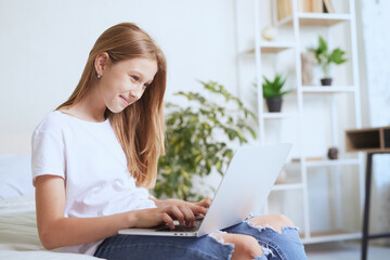 Young girl working at home on a laptop, online training
