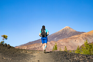 Fototapeta premium man hiking towards the volcano in El Teide national park Tenerife