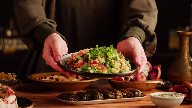 Tabbouleh Vegetable Salad close-up, middle eastern national traditional food. Muslim family dinner, Ramadan, iftar. Arabian cuisine, hummus and dolma dish on table.