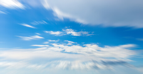 Panorama of blue sky with white clouds in clear weather with motion blur effect