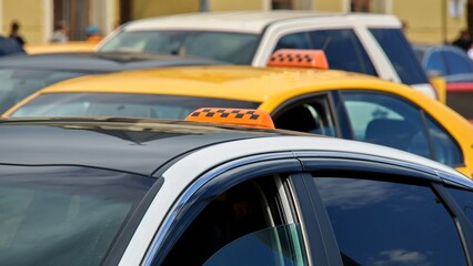 Yellow and white taxi cars stand in a tight traffic jam on a hot summer day