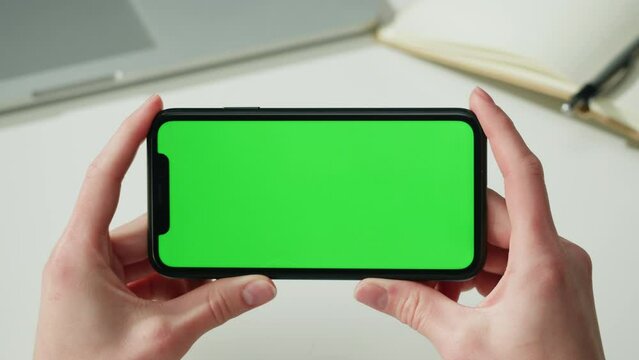 Smartphone with chroma key close-up. Holding mobile phone with green screen. Distance education, e-learning. Doctor workplace, woman nurse working. 