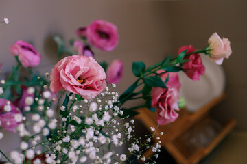 Vase with flowers on countertop in kitchen, selective focus.