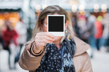 ältere Frau hält Polaroid Foto in der Hand