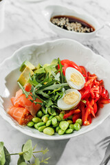 Poke bowl , buddha boul with fresh salmon,boiled eggs, avocado, cherry, bell pepper and greens