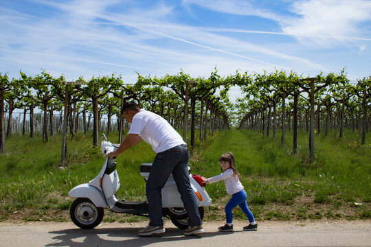 Nice image of a dad who pushes a motorbike with his daughter after being left on foot
