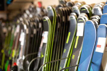 Large selection of skis for sale in the sports equipment store at mountain ski resort - obrazy, fototapety, plakaty