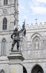 Fototapeta na wymiar Statue of Paul de Chomedrey in Place d'Armes with Notre-Dame Cathedral as Backdrop