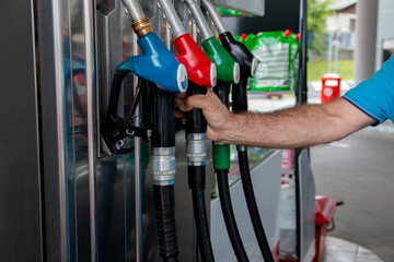 Mature man pouring petrol into tank of his vehicle on filling station. Travel,transportation and holiday