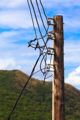 Countryside Power Supply Line Detail / Old wooden pole of power transmission at rural area with cables and ceramic insulators (copy space) - 513400555