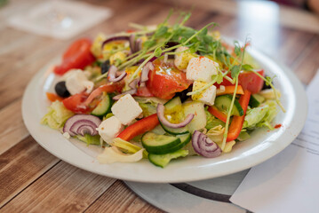 delicious vegetable salad with feta greek cheese on a plate in a restaurant close-up