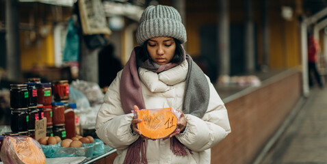 An African American woman is shopping at a local street market. He also chooses fresh fragrant...