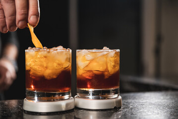 bartender preparing Manhattan drink with cherry and ice
