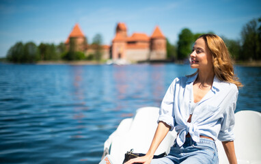 Young beautiful woman relazing at the Castle of Trakai, famous landmark in Lithuania near Vilnius