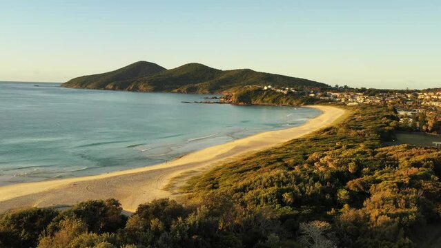 Aerial flying over sand dunes and scenic One Mile beach in Forster as 4k.
