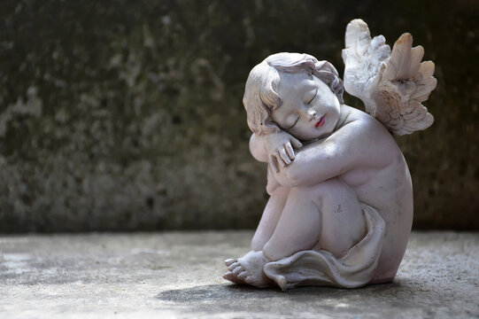 Guardian angel sleeping on concrete background with copy space