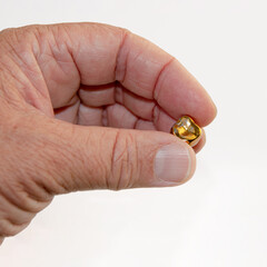a fallen gold tooth in the hand of an elderly man.. - 513404368