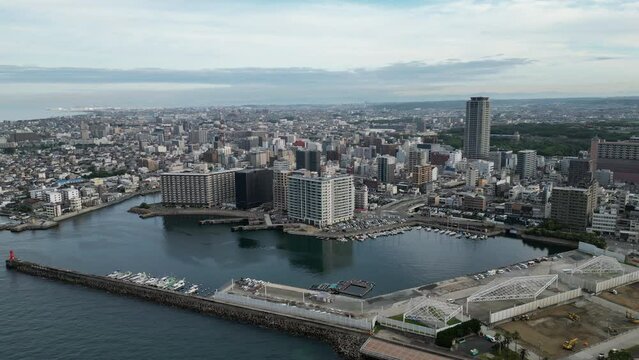 Rotating over central Akashi tower building and sprawling coastal cityscape