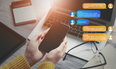 Woman with mobile phone chatting online at workplace