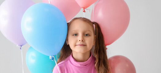 Cute little girl with balloons on grey background