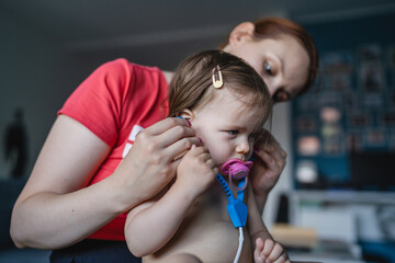 One woman Female caucasian mother playing with her child daughter at home role play with doctor set Early development concept family leisure growing up concept copy space