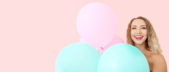 Fototapeta na wymiar Beautiful happy young woman with balloons on pink background with space for text