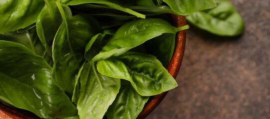 Bowl with fresh basil leaves on table, closeup