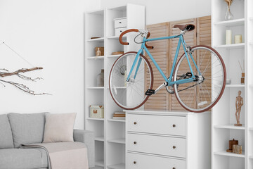 Modern bicycle on chest of drawers in light living room