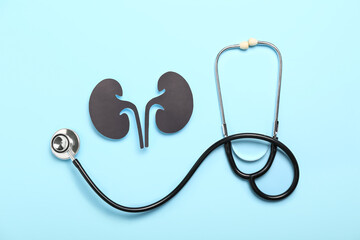 Paper kidneys and stethoscope on blue background