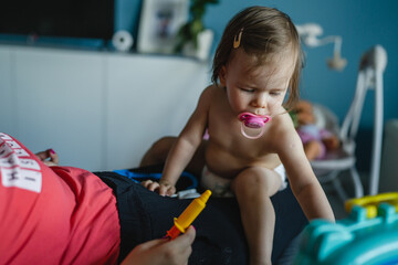 One girl toddler caucasian sitting with parent and playing with toys Early development learning and playing growing up concept