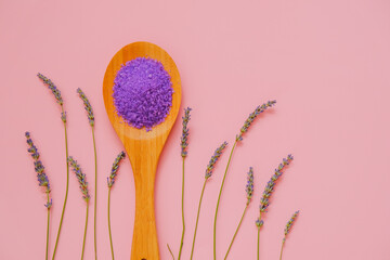  lilac salt with lavender extract in wooden spoon and lavender flowers on a pink background.purple sea bath salt . Flower bath salt.Aromatherapy and spa.body cosmetic with lavender extract.