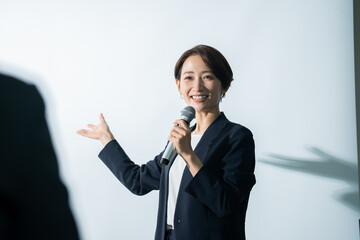 マイクを持ちプレゼンする日本人女性