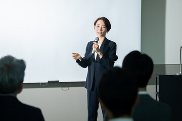 マイクを持ちプレゼンする日本人女性