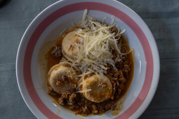 dish of sorrentinos with bolognese sauce