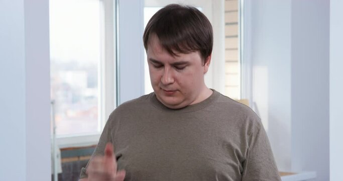 Young man comes out of kitchen with cup in hand, anticipating enjoyment of his drink, when he sees something shocking, open his eyes and mouth wide, then drop mug with beverage