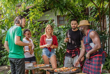 Naklejka na ściany i meble Group of friends diversity making barbecue in the garden backyard