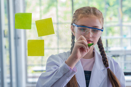 schoolgirl study science subjects and use marker write on board glass