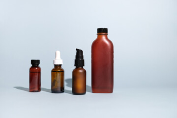The set of amber glass bottles for skincare on blue background. mock-up and beauty concept.