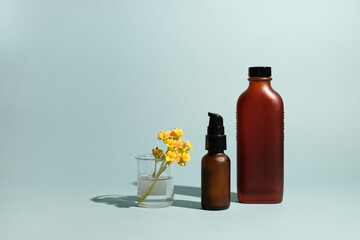 Two amber glass bottle wit yellow flower.