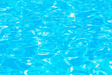 Swimming pool water surface with sparkling light reflections. Aqua background.