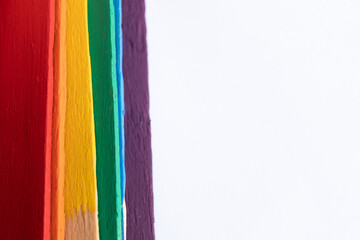 seis palos de madera, batelenguas, arcoiris multicolor sobre base de mármol clara