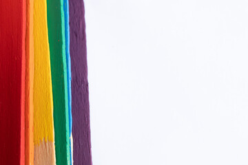 seis palos de madera, batelenguas, arcoiris multicolor sobre base de mármol clara