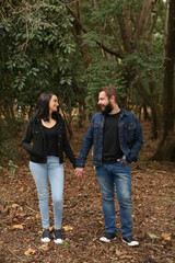 Portrait of a Cheerful Couple Looking Each Other at the Park. Romantic Relationship Concept.