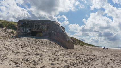 Ruin of bunker at the coast of the north sea on the beach with dune landscape near Dunkirk,...