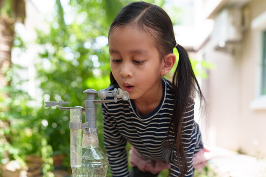 A 6 years old asian little girl learning science experiment at home and planting with recycle plastic bottle, concept of STEM, education, montessori, nature, environment, weather for kid.