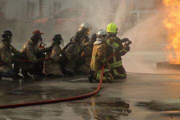 Firefighters using Twirl water fog type fire extinguisher to fighting with the fire flame from oil...